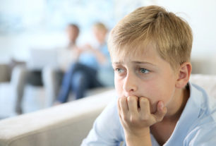 Children sat looking upset with parents in the background