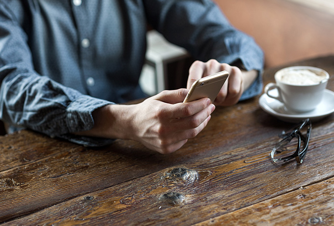 Man holding a mobile phone checking out the best MensLine Australia posts of 2017