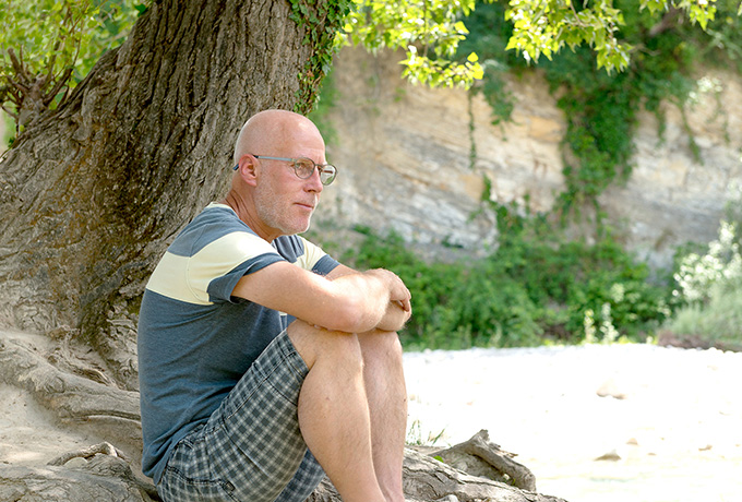 Man suffering depression sitting under a tree