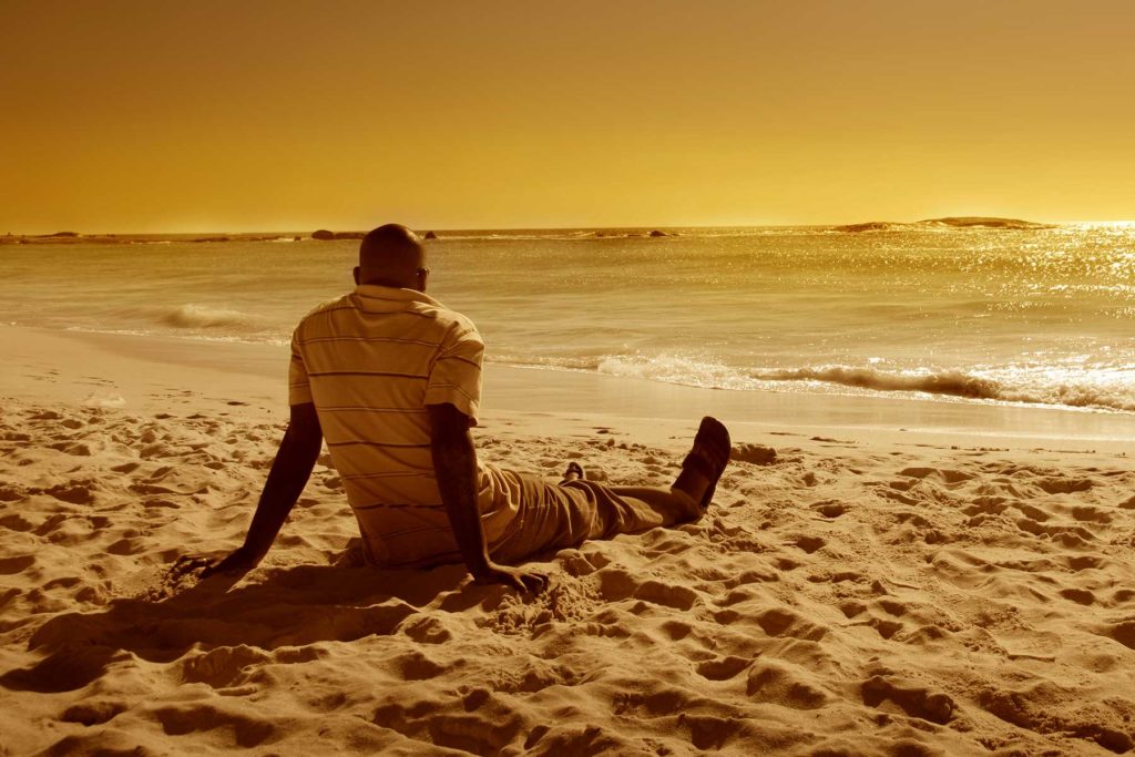 Man having a moment of mindfulness on a beach