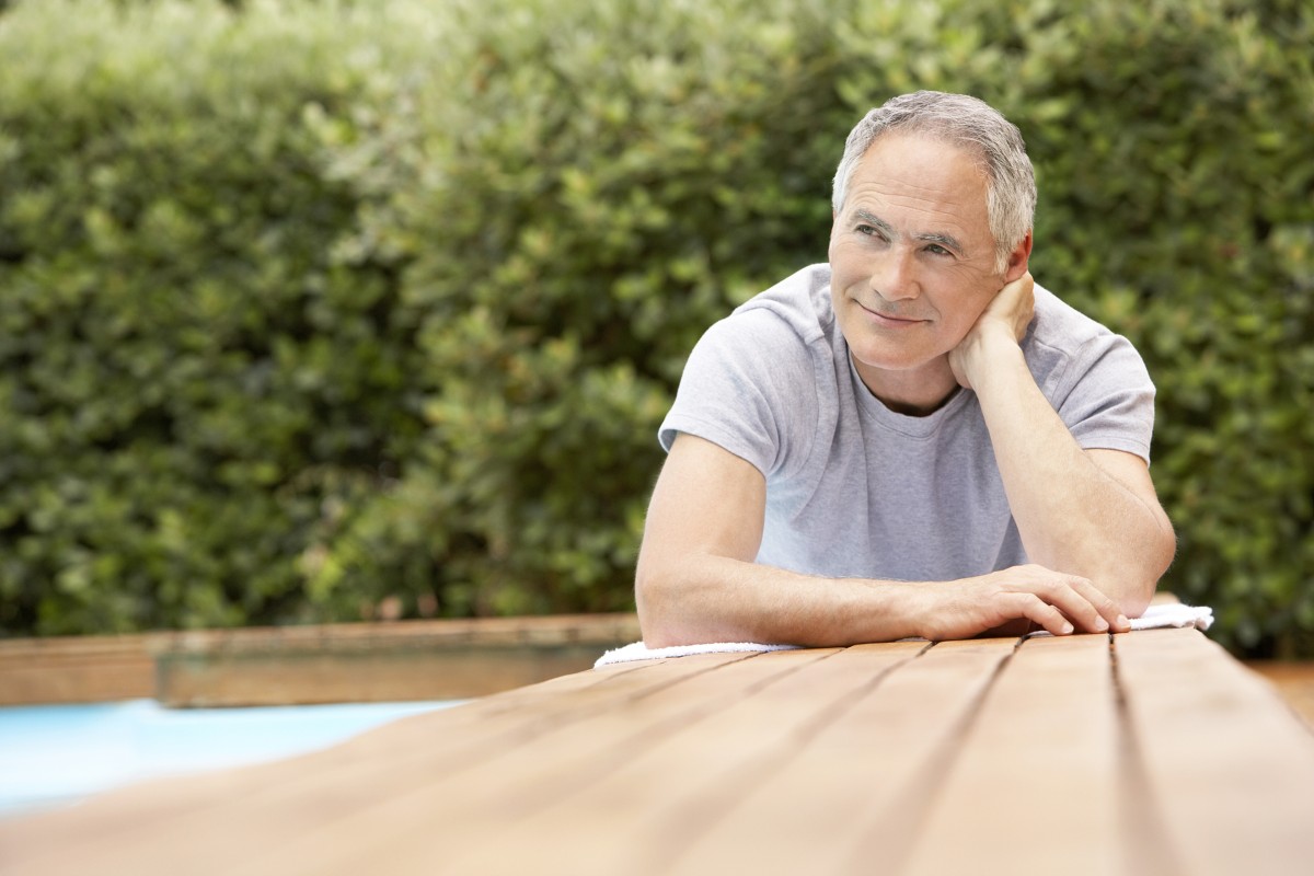 Man looking happy sat at a table - Emotional wellbeing