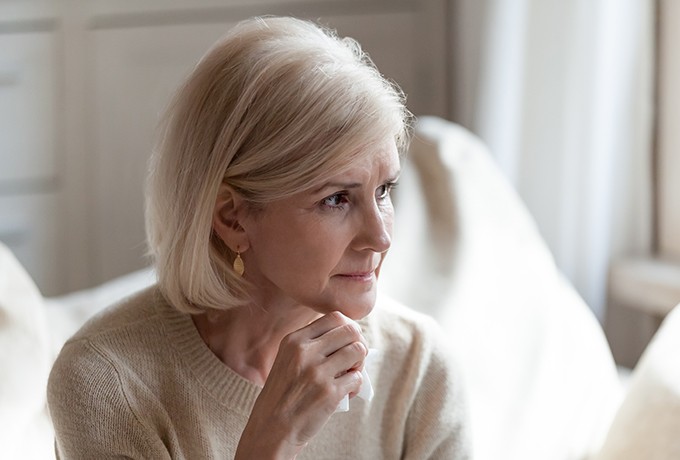 Women sat on a couch looking concerned