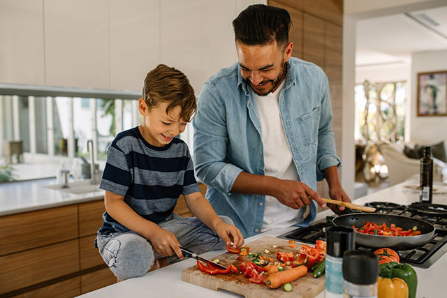 Father and son cooking healthy meal in the kitchen