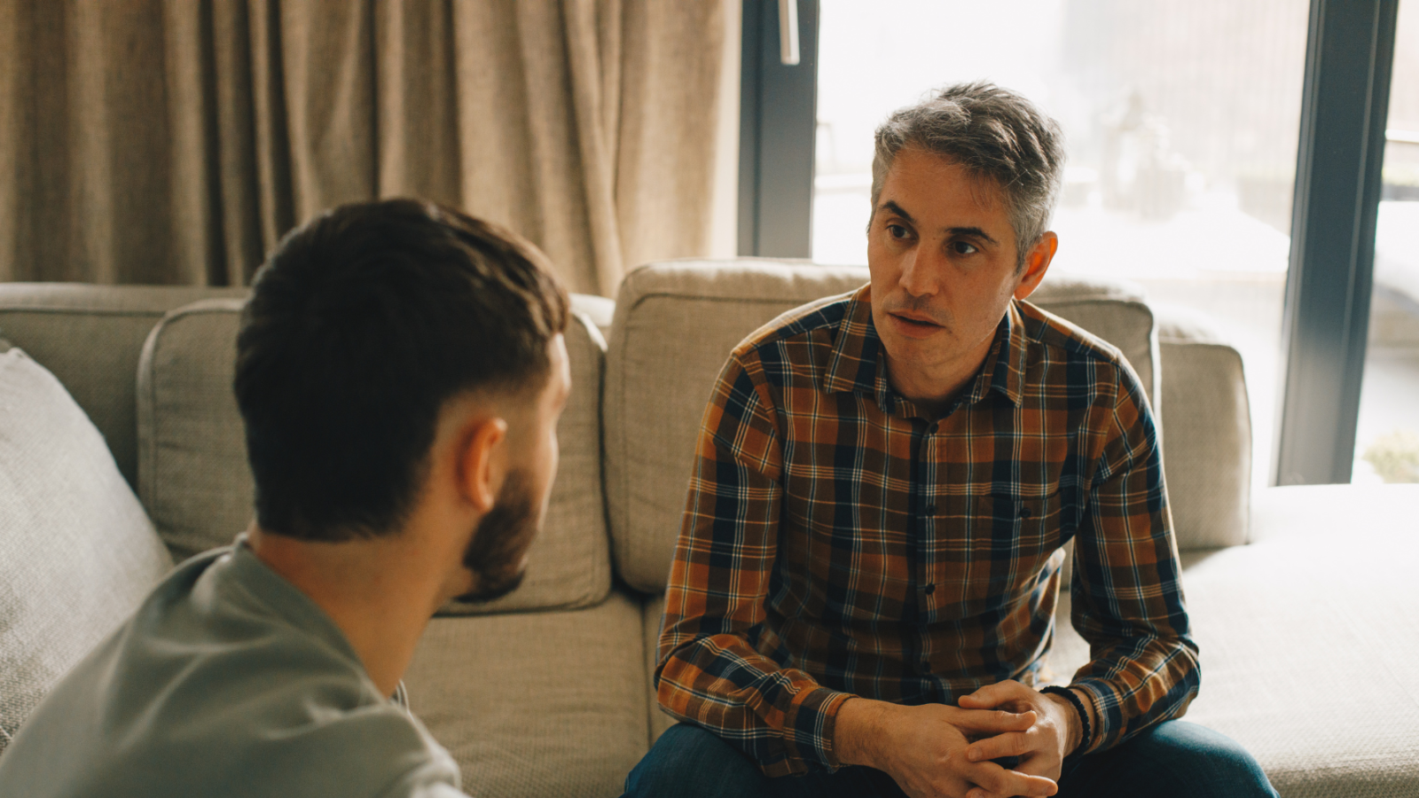 Two men sitting inside having a serious conversation