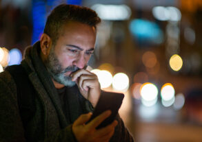 Man looking at phone with serious expression