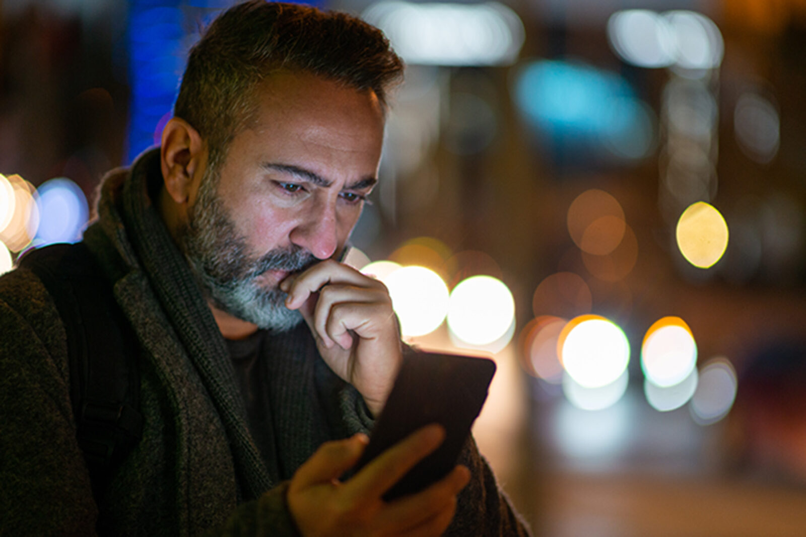 Man looking at phone with serious expression