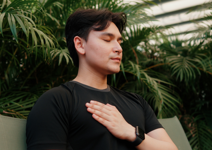 Man meditating with one hand on his chest
