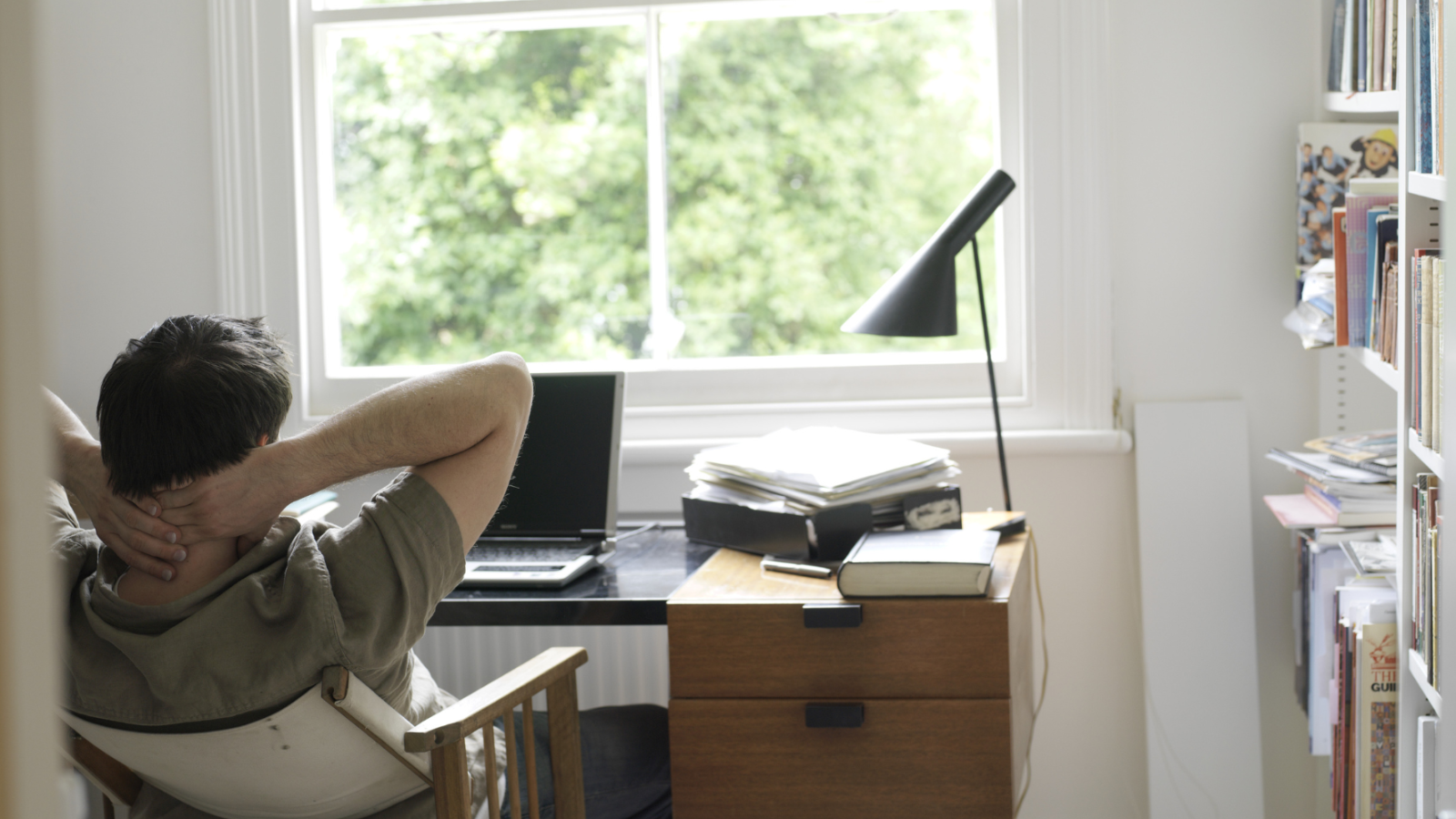 Man sitting at desk in front of laptop looking tense