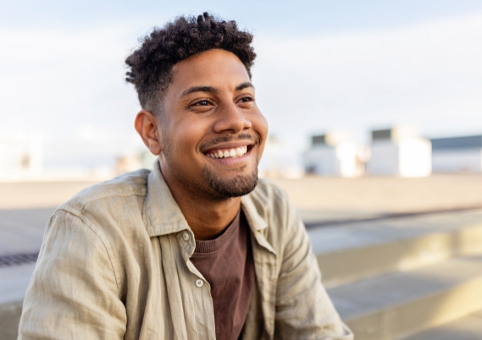 Portrait of young male outside at the beach looking hopeful and optimistic