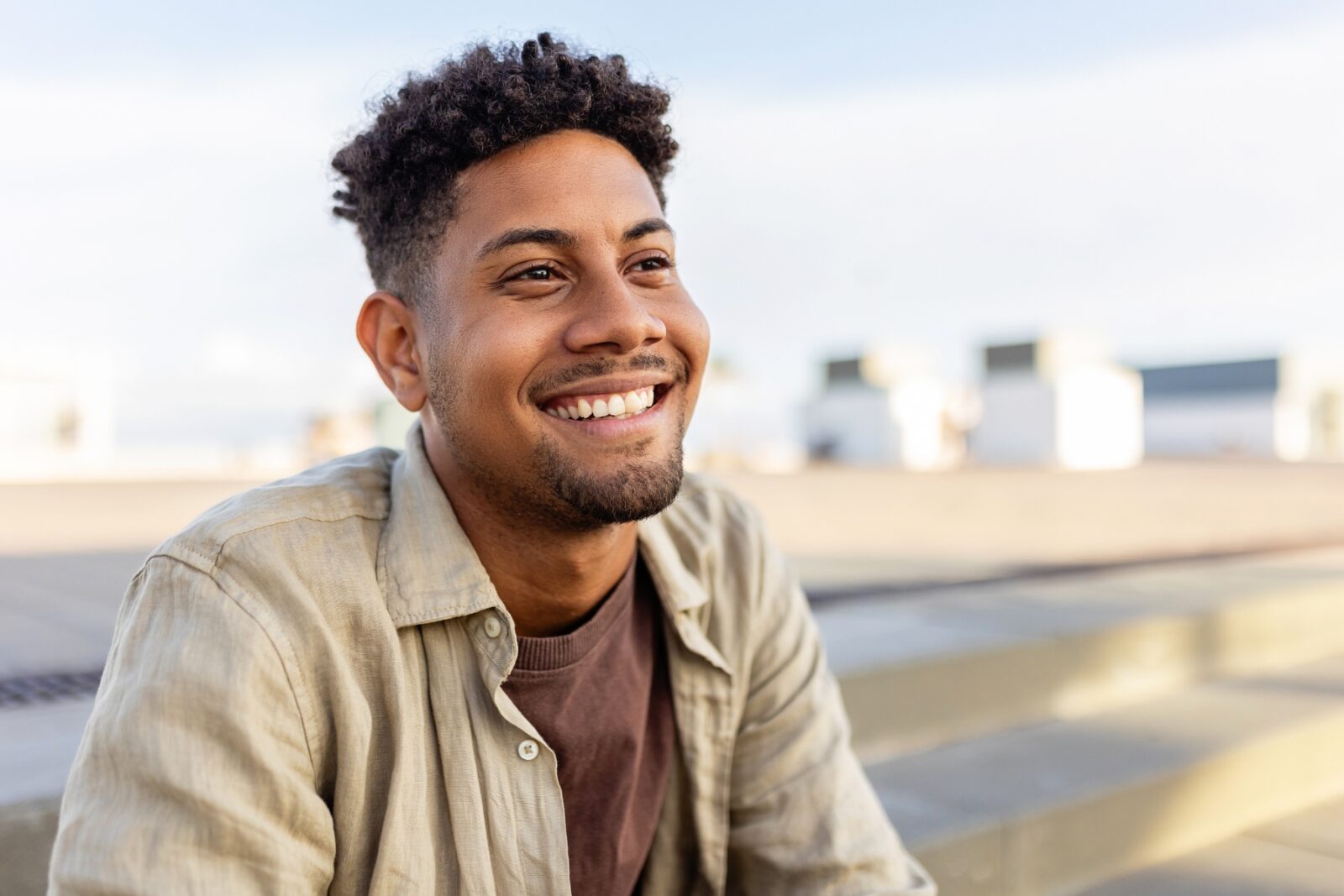 Portrait of young male outside at the beach looking hopeful and optimistic